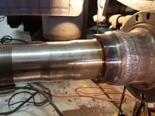 A large metal object is being worked on in a garage.