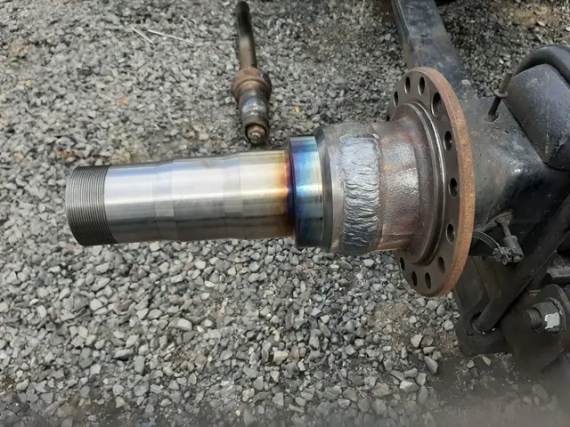 A close up of a metal object on a gravel road.