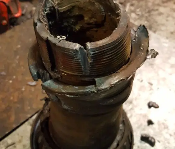 A close up of a broken bearing on a table.